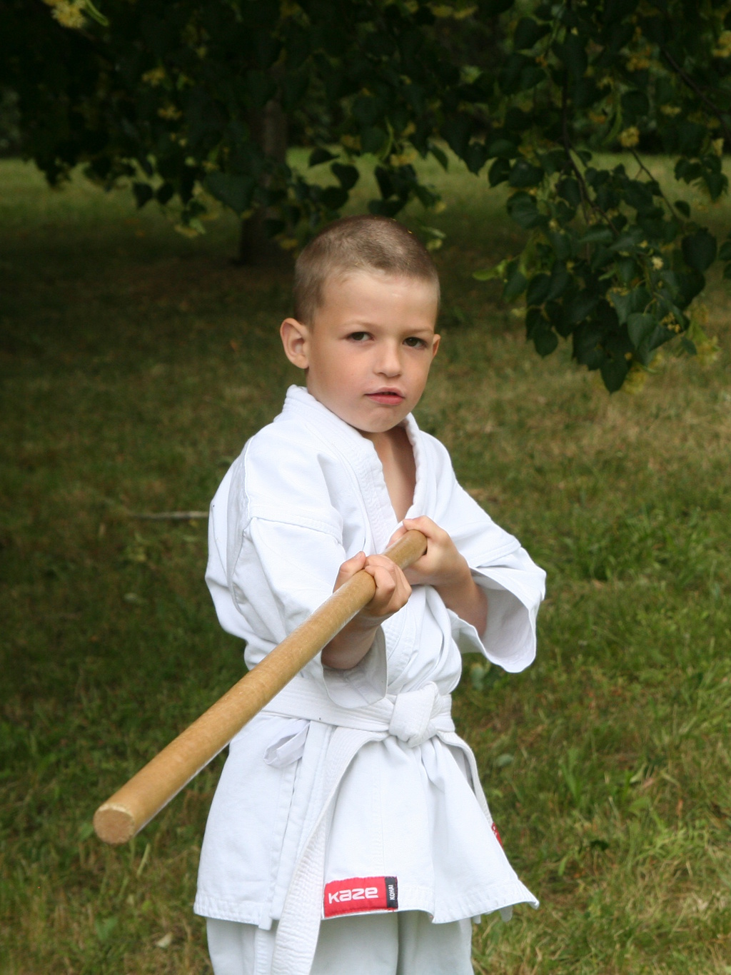malý aikido bojovník trénuje so zbraňou